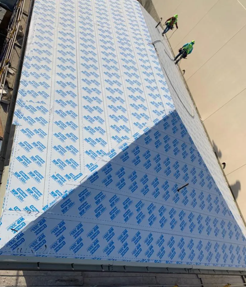 Professional roofers installing underlayment on a metal roof in Speedway